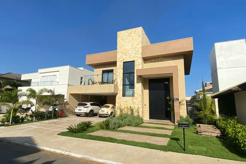 Fachada da Casa CH, no Jardins Mônaco, com revestimento de pedra e entrada da garagem