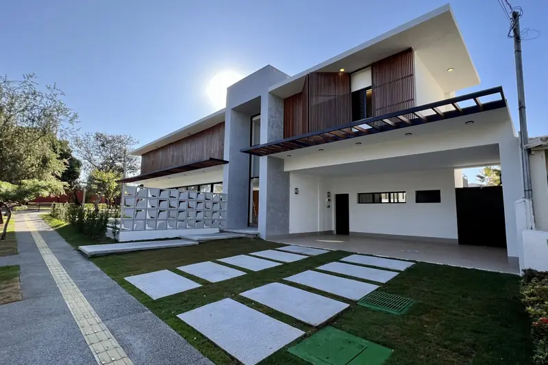 Fachada da Casa Praia do Cerrado, no Portal do Sol II, com painéis de madeira e jardim na frente