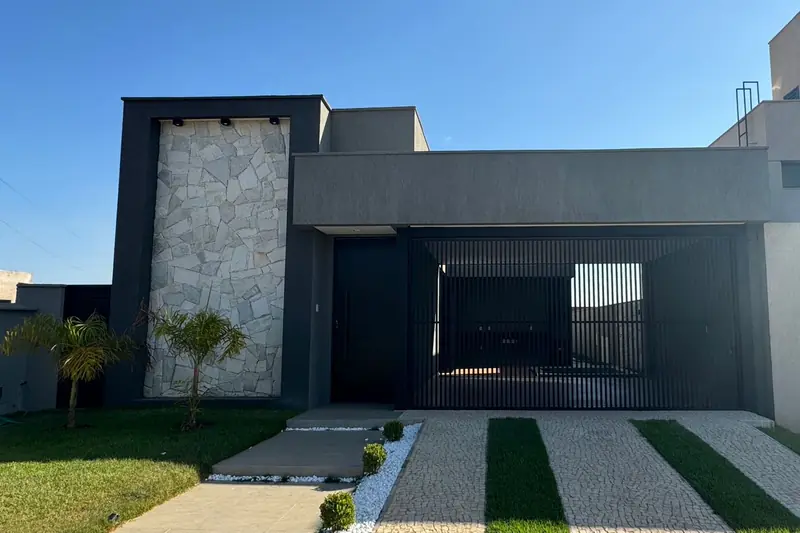 Fachada da Casa RP, no Jardins Bolonha, em cinza-escuro com painel de pedra